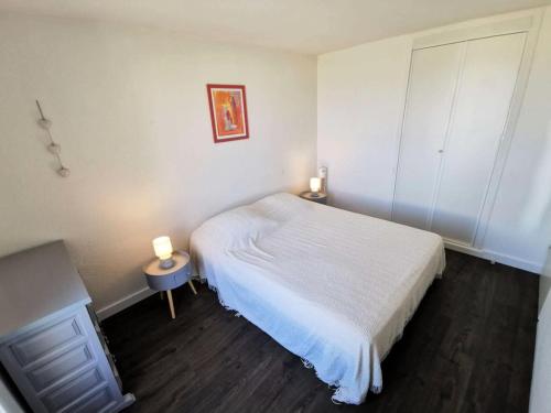 - une petite chambre avec un lit blanc et une table dans l'établissement Résidence Les Aigues Marines - Bel appartement trois pièces avec vue sur mer à Port Leucate. Réf: 1AM_187 MAE-6304, à Port-Leucate