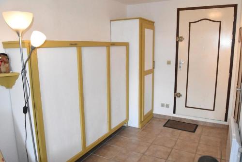 Cette chambre comprend un placard avec une porte et une lampe. dans l'établissement Résidence Les Portes De La Mediterranee - STUDIO 2 PERSONNES 3 couchages PORT LEUCATE MAE-6324, à Port-Leucate