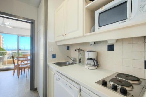 une cuisine avec un évier et un micro-ondes dans l'établissement Hyeres Parc - maeva Home - Studio 1 pièce 4 personnes Confort MAE-7731, à Hyères
