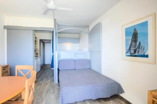 une petite chambre avec un lit et une table dans l'établissement Hyeres Parc - maeva Home - Studio 1 pièce 4 personnes Confort MAE-7731, à Hyères