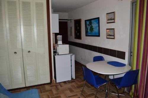 uma cozinha com uma mesa e cadeiras e um frigorífico em Résidence LES CYCLADES - Studio pour 2 Personnes 54 em Port Leucate