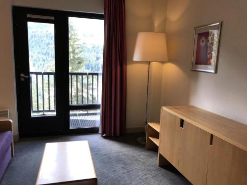 un salon avec une table et une grande fenêtre dans l'établissement Residence De La Foret - Appartement lumineux · Proche des pistes · Balcon MAE-5774, à Flaine