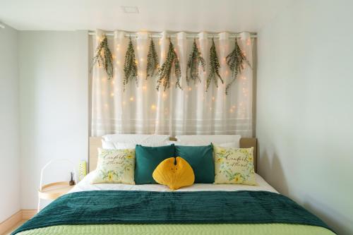 a bedroom with a bed with green and yellow pillows at t-t-haus in Bangkok