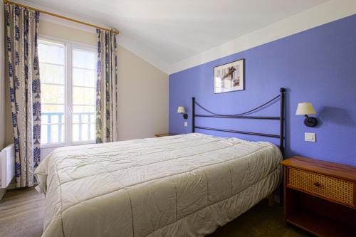 une chambre avec un grand lit aux murs bleus dans l'établissement Village Moliets - maeva Home - Maison 3 pièces 6 personnes Sélection MAE-0065, à Moliets-et-Maa