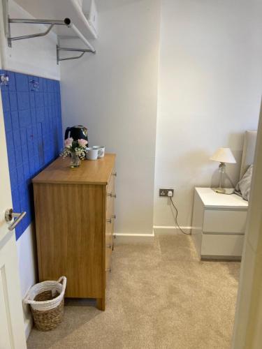 a room with a wooden dresser with flowers on it at House on the corner in Thame