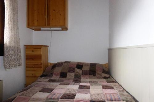 um quarto com uma cama e um armário de madeira em Résidence Le Royal - 2 Pièces pour 4 Personnes 034 em Combloux