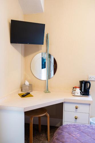 a room with a desk with a mirror on the wall at Park Manor Hotel in Scarborough