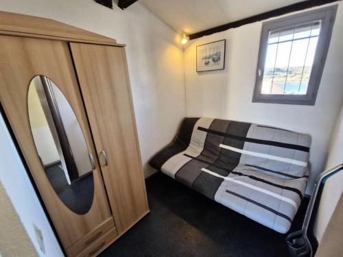 une petite chambre avec un lit et un miroir dans l'établissement Résidence Le Grand Large - 2 Pièces 4 couchages PORT LEUCATE MAE-6534, à Port-Leucate