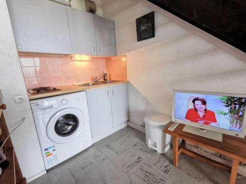 une petite cuisine avec un évier et une machine à laver dans l'établissement Résidence LES PLAGES D'ARGOS - 3 Pièces pour 6 Personnes 54, à Port-Leucate