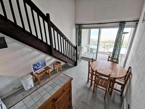 une pièce avec une table, des chaises et un escalier dans l'établissement Résidence LES PLAGES D'ARGOS - 3 Pièces pour 6 Personnes 54, à Port-Leucate