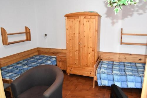 - une chambre avec un lit, une armoire et une chaise dans l'établissement Résidence Les Villas Du Mail - VILLA 3 PIECES 6 couchages PORT LEUCATE MAE-6594, à Port-Leucate