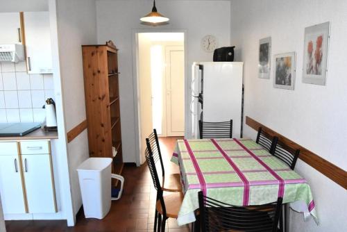 une cuisine avec une table et un réfrigérateur dans l'établissement Résidence Les Villas Du Mail - VILLA 3 PIECES 6 couchages PORT LEUCATE MAE-6594, à Port-Leucate