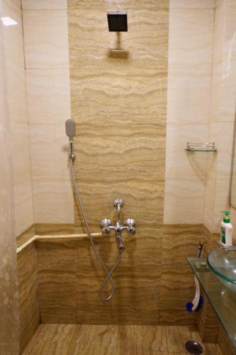a shower with a hose in a bathroom at Hammock Hostels - Bandra in Mumbai