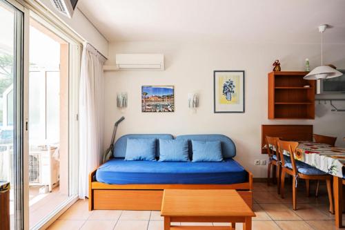 - une chambre avec un lit bleu et une table dans l'établissement Résidence les Rivages du Parc - maeva Home - Studio 5 personnes - Confort MAE-0812, à Menton