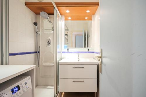 une salle de bain blanche avec un lavabo et une douche dans l'établissement Résidence les Rivages du Parc - maeva Home - Studio 5 personnes - Confort MAE-0812, à Menton