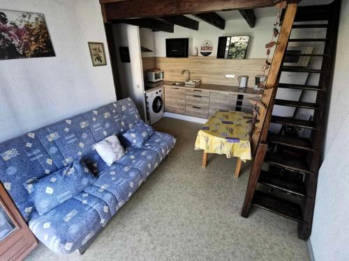 un salon avec un canapé bleu et une table dans l'établissement Résidence Le Hameau Des Pecheurs - VILLA T2 MEZZANINE 6 couchages PORT LEUCATE MAE-6614, à Port-Leucate