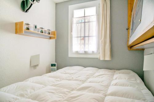 un lit blanc dans une chambre avec une fenêtre dans l'établissement Résidence Port Bourgenay - maeva Home - Appartement 2 pièces 5 personnes - Sélection - super Home MAE-1882, à Talmont-Saint-Hilaire