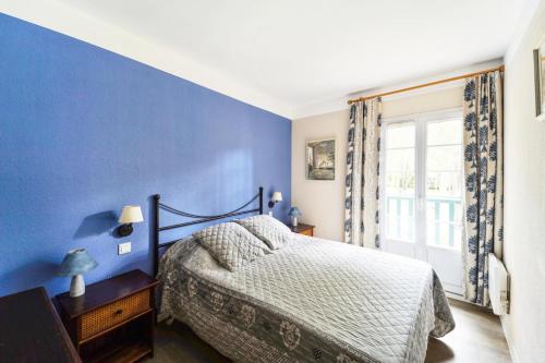 ein blaues Schlafzimmer mit einem Bett und einem Fenster in der Unterkunft Village Moliets - maeva Home - Maison 3 pièces 6 personnes Selection MAE-2003 in Moliets-et-Maa