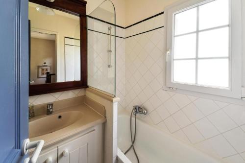 ein Badezimmer mit Badewanne und Waschbecken und einem Fenster in der Unterkunft Village Moliets - maeva Home - Maison 3 pièces 6 personnes Selection MAE-2003 in Moliets-et-Maa