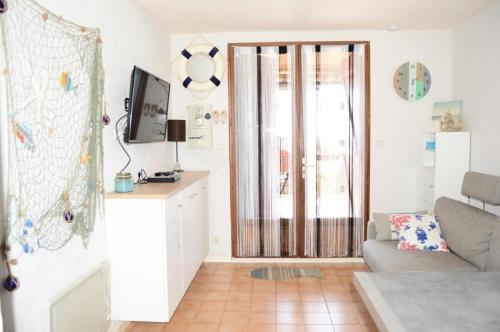 un salon avec un canapé et une télévision dans l'établissement Résidence Grande Bleue - 2 Pièces 4 couchages PORT LEUCATE MAE-6694, à Port-Leucate