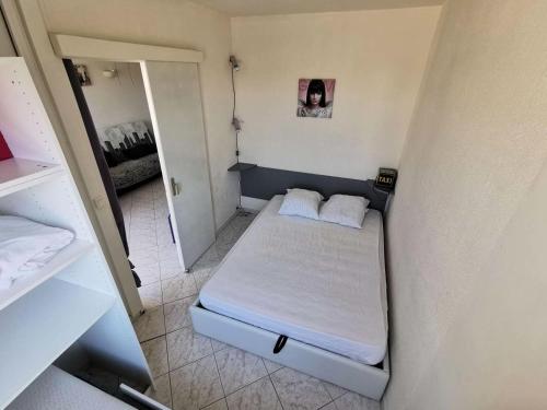 une petite chambre avec un lit et un miroir dans l'établissement Résidence Terrasses De La Mediterranee 1 - 2 Pièces 4 couchages PORT LEUCATE MAE-6794, à Port-Leucate