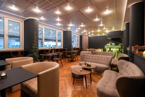コペンハーゲンにあるHotel Maritimeのソファ、テーブル、椅子が備わるレストラン