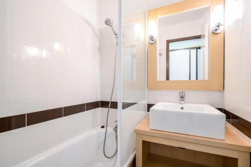 une salle de bain blanche avec un lavabo et une douche dans l'établissement Résidence Port du Crouesty - maeva Home - Studio 5 personnes - Confort - vue mer MAE-2887, à Arzon