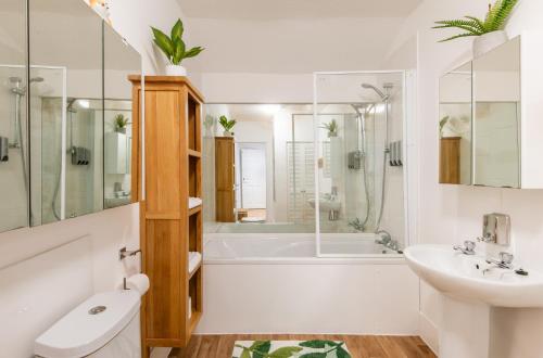 a bathroom with a tub and a sink and a toilet at Brighton & Hove Beach - group or family fun in Brighton & Hove