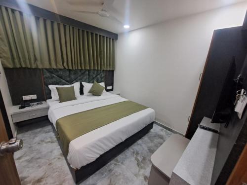 a bedroom with a large bed in a room at HOTEL AKASH in Ahmedabad