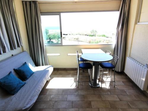 sala de estar con sofá y mesa en Résidence LES NEFS DES SABLES - Studio pour 5 Personnes 924, en Port Leucate