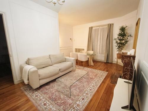 sala de estar con sofá y mesa en Superbe Appartement Parisien, en Villeneuve-Saint-Georges