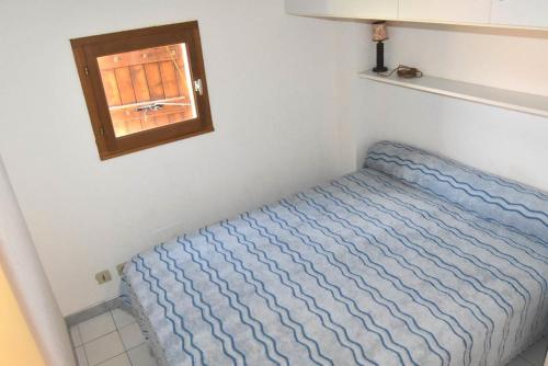 un petit lit dans une chambre avec une fenêtre dans l'établissement Résidence Les Captivantes - Villa deux pièces mezzanine avec vue sur mer. Réf: 1CAPT_Q4 MAE-6904, à Port-Leucate