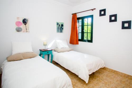 two beds in a room with a window at Sunny Golf Villas in Puerto del Carmen