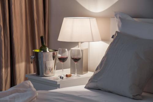 a bed with two glasses of wine and a lamp at Apartments Deja Views - Žnjan beach in Split