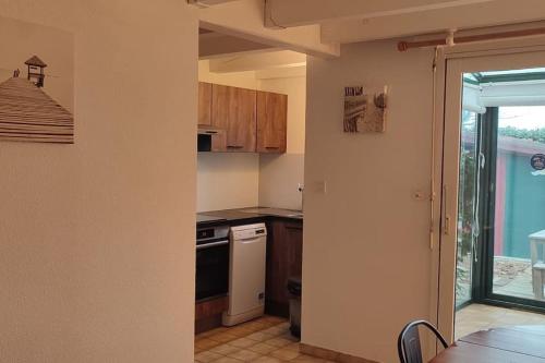 Il comprend une cuisine équipée d'une cuisinière et d'un lave-vaisselle. dans l'établissement Maisonnette 3 chambres - Confort, à Biscarrosse