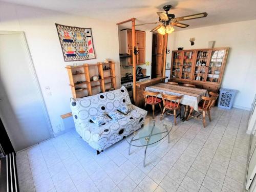 un salon avec un canapé, une table et des chaises dans l'établissement Résidence Terrasses De La Mediterranee 1 - 2 Pièces 4 couchages PORT LEUCATE MAE-7064, à Port-Leucate