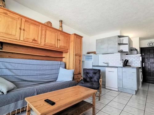 un salon avec un canapé et une table et une cuisine dans l'établissement Résidence Les Cyclades - 3 Pièces 6 couchages PORT LEUCATE. Réf: 2CYC_133C MAE-7084, à Port-Leucate