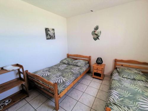 - une chambre avec 2 lits et une table de nuit dans l'établissement Résidence Les Cyclades - 3 Pièces 6 couchages PORT LEUCATE. Réf: 2CYC_133C MAE-7084, à Port-Leucate