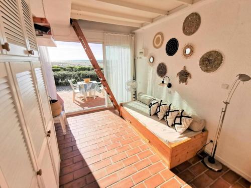 Cette chambre dispose d'un lit et d'un balcon avec une table. dans l'établissement Résidence Maisons De La Mer 1 - Magnifique studio rénové pour deux personnes en front de mer à Port Leucate. Réf: 1MM1_91 MAE-6954, à Port-Leucate