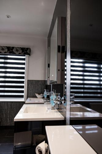 a bathroom with three sinks and two mirrors at Park Manor Hotel in Scarborough