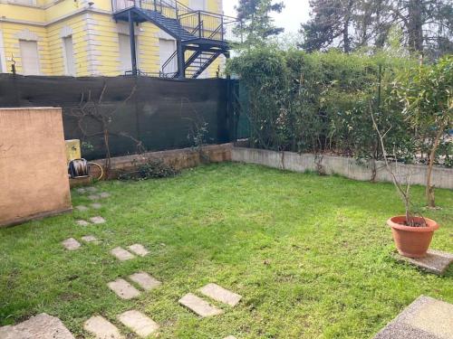 um quintal com um vaso de árvore e uma cerca em Sereno house apartment em Brescia