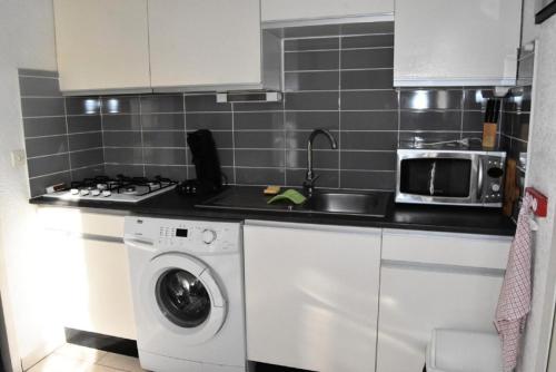 une cuisine avec un lave-linge et un micro-ondes dans l'établissement Résidence Equateur - APPT T2 CAB OU MEZZ 5 couchages PORT LEUCATE. Réf: 2MS3_32 MAE-7124, à Port-Leucate