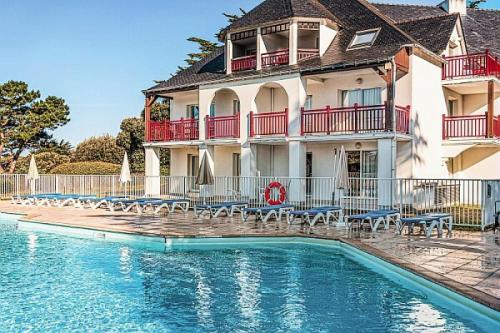 une maison avec piscine devant un immeuble dans l'établissement Le Domaine De Cramphore - maeva Home - Appartement 2 pièces 4 personnes Confort MAE-5518, au Pouliguen