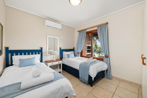 a bedroom with two beds and a window at San Lameer Villa 10415 - 2 Bedroom Classic - 4 pax - San Lameer Rental Agency in Southbroom