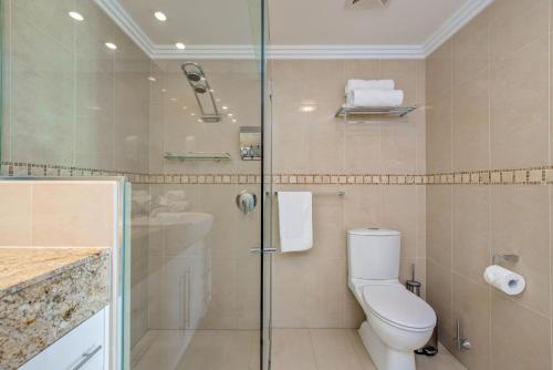 a bathroom with a toilet and a glass shower at 'The Dreamscape' Sea View Serenity on the Esplanade in Cairns
