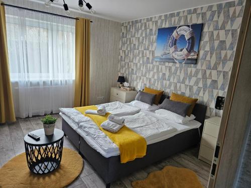 a bedroom with a large bed with a yellow blanket at Apartamenty Premium Biznes Rumia in Rumia