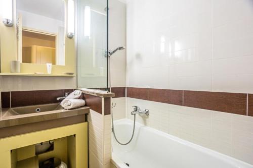 une salle de bain avec une baignoire et un lavabo dans l'établissement Résidence le Village de Cap Esterel - maeva Home - Studio 4 personnes - Sélection MAE-4173, à Saint-Raphaël