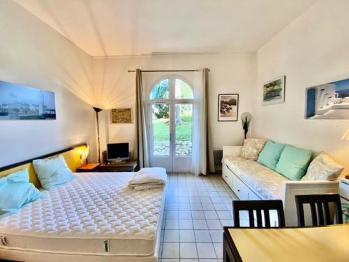 a living room with a bed and a couch at Résidence Le Palais des Gouverneurs - maeva Home - Studio 3 personnes Sélec 69 in Saint-Martin-de-Ré