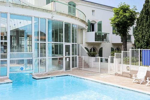 une maison avec une piscine et un bâtiment dans l'établissement Résidence Le Palais des Gouverneurs - maeva Home - Studio 3 personnes Sélection MAE-4469, à Saint-Martin-de-Ré