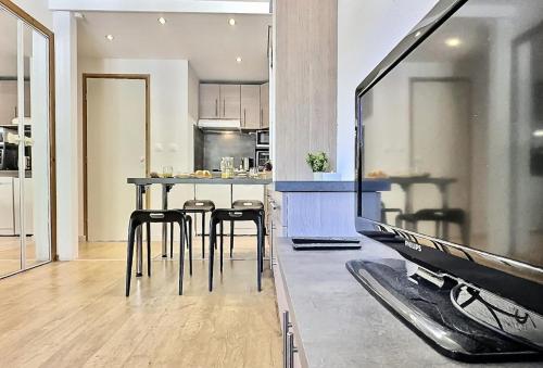 une cuisine avec une table et quelques chaises dans une pièce dans l'établissement Résidence Les Jardins De Val - Agréable studio cabine complètement rénové pour 4 personnes situé à Val d'isère à 350m du centre du village et 450m des pistes MAE-0164, à Val dʼIsère